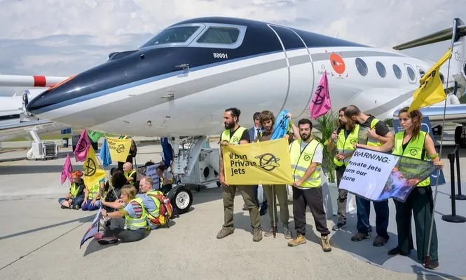Activistas ambientales protestan por la emisión de CO2 de los jets privados en una exhibición aérea en Ginebra.