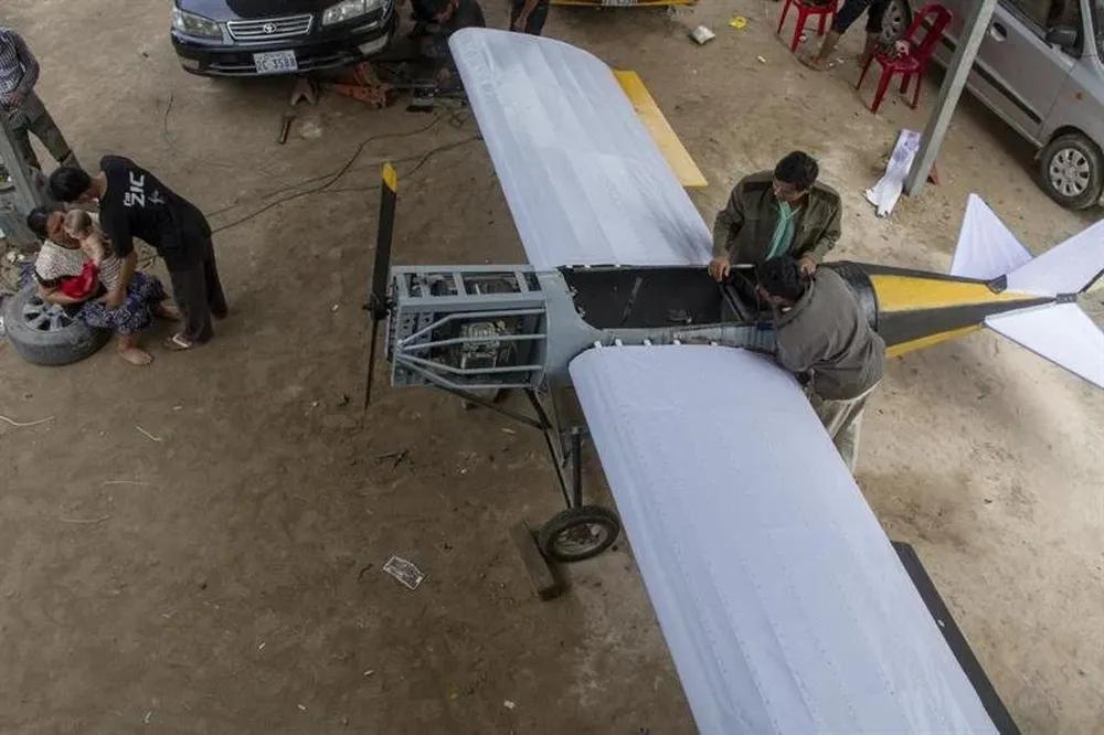 Varios vecinos observan el avión que el mecánico camboyano Paen Long ha construido durante un año a través de tutoriales en internet