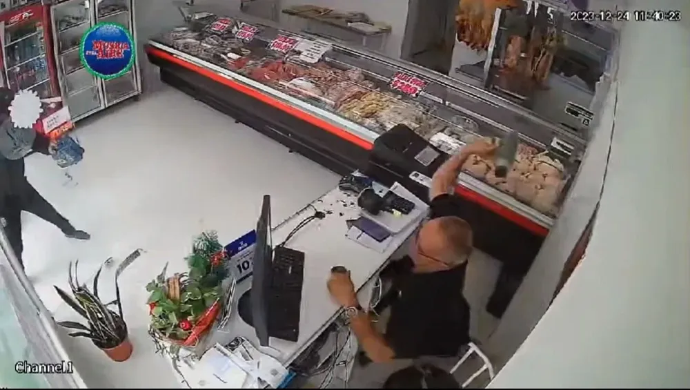 Momento en el que el comerciante tira su termo al delincuente