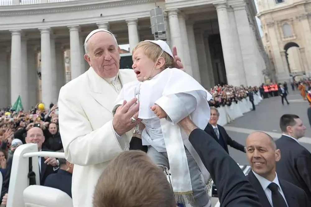 Vaticano. Francisco besa a un niño vestido de papa en la Plaza de San Pedro