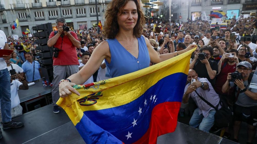 La presidenta de la comunidad de Madrid, Isabel Díaz Ayuso, sostiene una bandera de Venezuela