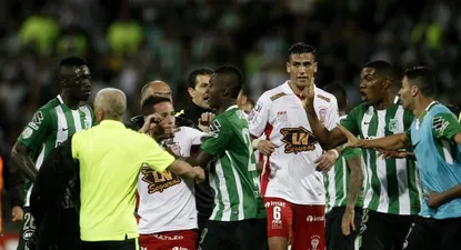 El uruguayo Mario Risso en primer plano no participa; atrás empiezan los incidentes