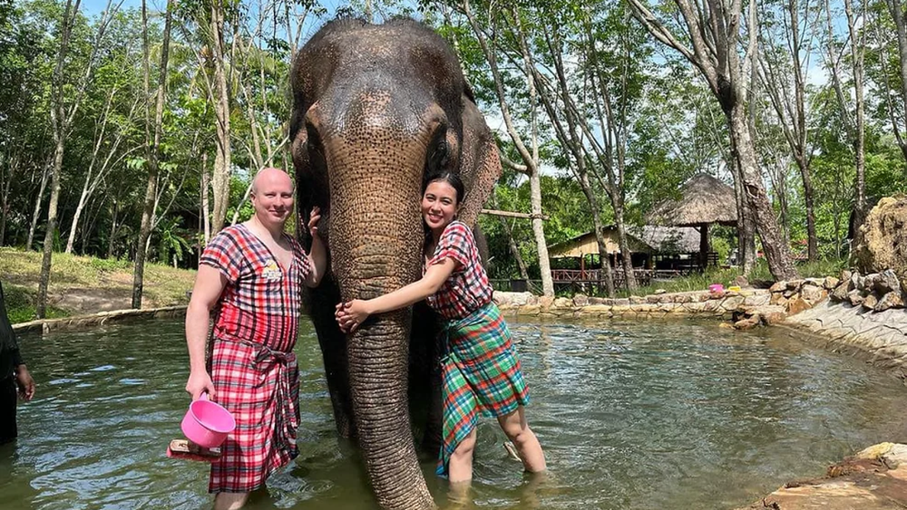 Dos turistas en un parque de elefantes en Tailandia