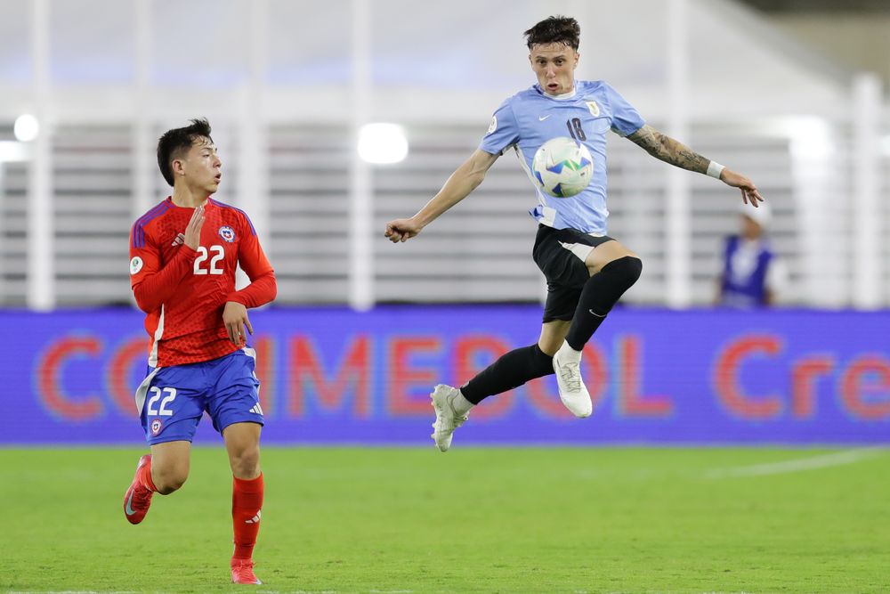 Leandro Hernández de Chile disputa un balón con Germán Barbas de Uruguay
