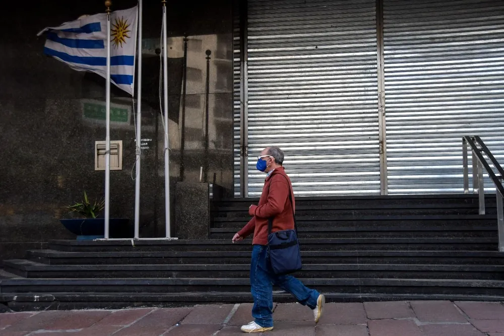 Un hombre de tapaboca camina por el centro de Montevideo