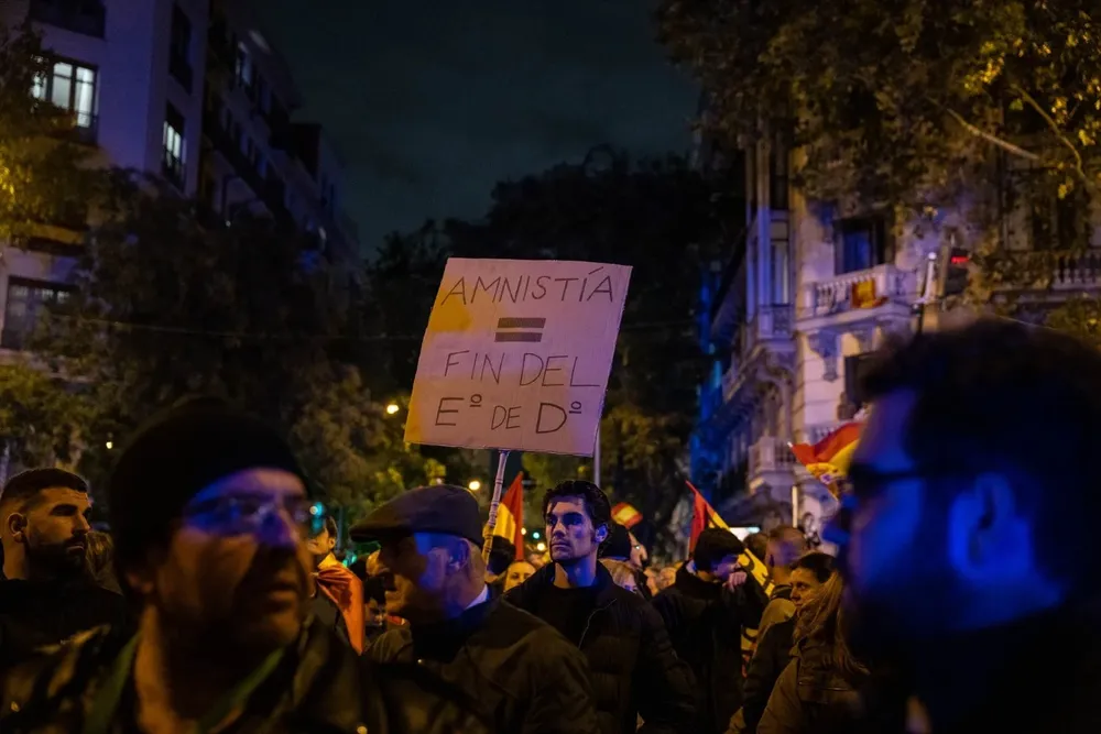 Decenas de personas con banderas y pancartas, durante una concentración en contra de la amnistía, en la sede del PSOE en la calle Ferraz, a 8 de noviembre