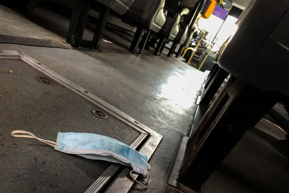 Tapabocas tirado en el piso de un ómnibus
