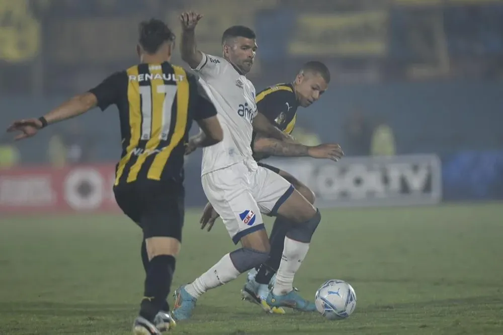 Gigliotti y Léo Coelho pelean por la pelota en el clásico entre Nacional y Peñarol
