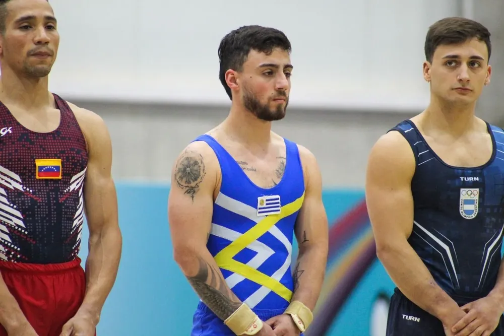 Víctor Rostagno con el escudo de Uruguay; el gimnasta se lesionó la rodilla y no podrá seguir compitiendo en los Juegos Odesur