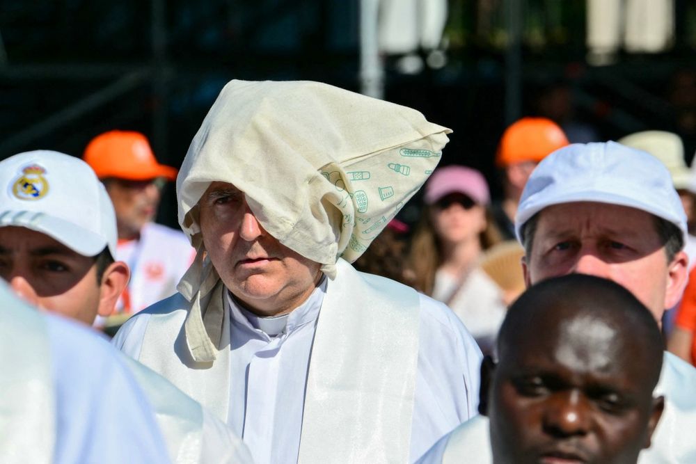 Un hombre se protege la cabeza del sol durante la Santa Misa oficiada por el Papa León XIV en la Plaza de Cibeles de Madrid el 7 de junio de 2026. Un hombre se protege la cabeza del sol durante la Santa Misa oficiada por el Papa León XIV en la Plaza de Cibeles de Madrid el 7 de junio de 2026.