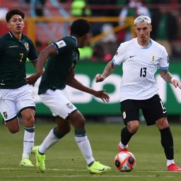 Diego Román de Bolivia disputa un balón con Guillermo Varela de Uruguay por Eliminatorias