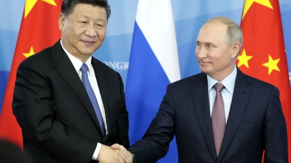 Xi Jinping y Vladimir Putin se saludan