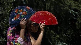 Dos mujeres se protegen de las altas temperaturas en Madrid
