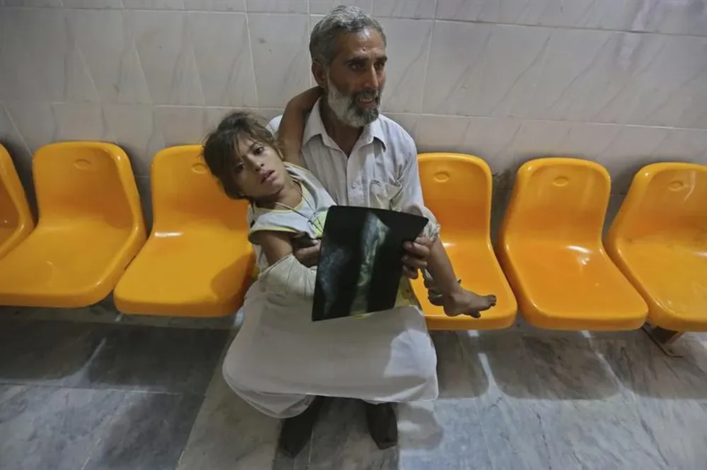 Una niña herida espera a ser atendida en un hospital tras un atentado en contra de un autobús en Peshawar (Pakistán)