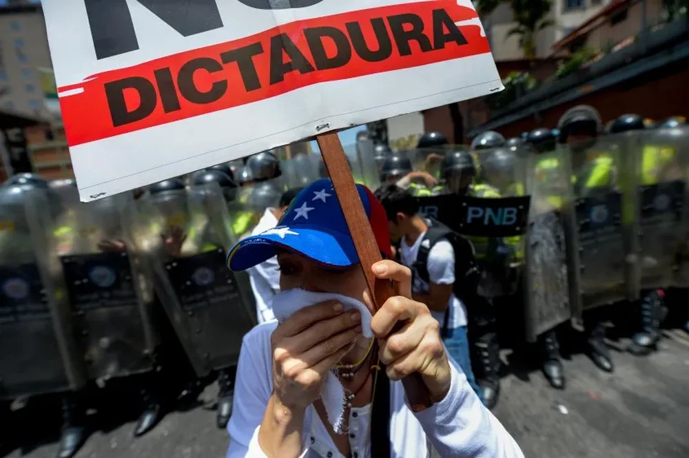 Activistas venezolanos de la oposición chocan contra la Policía durante una protesta en contra del gobierno de Nicolás Maduro, en las calles de Caracas.