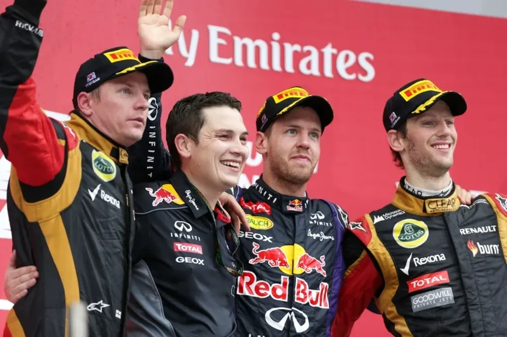 El piloto alemán (flanqueado por los hombres de Lotus) a punto de calzarse otra corona