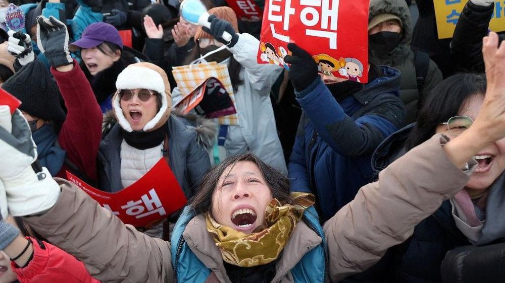 La gente celebra después de que el parlamento de Corea del Sur aprobara una segunda moción de impeachment contra el presidente Yoon Suk Yeol por su decreto de ley marcial.