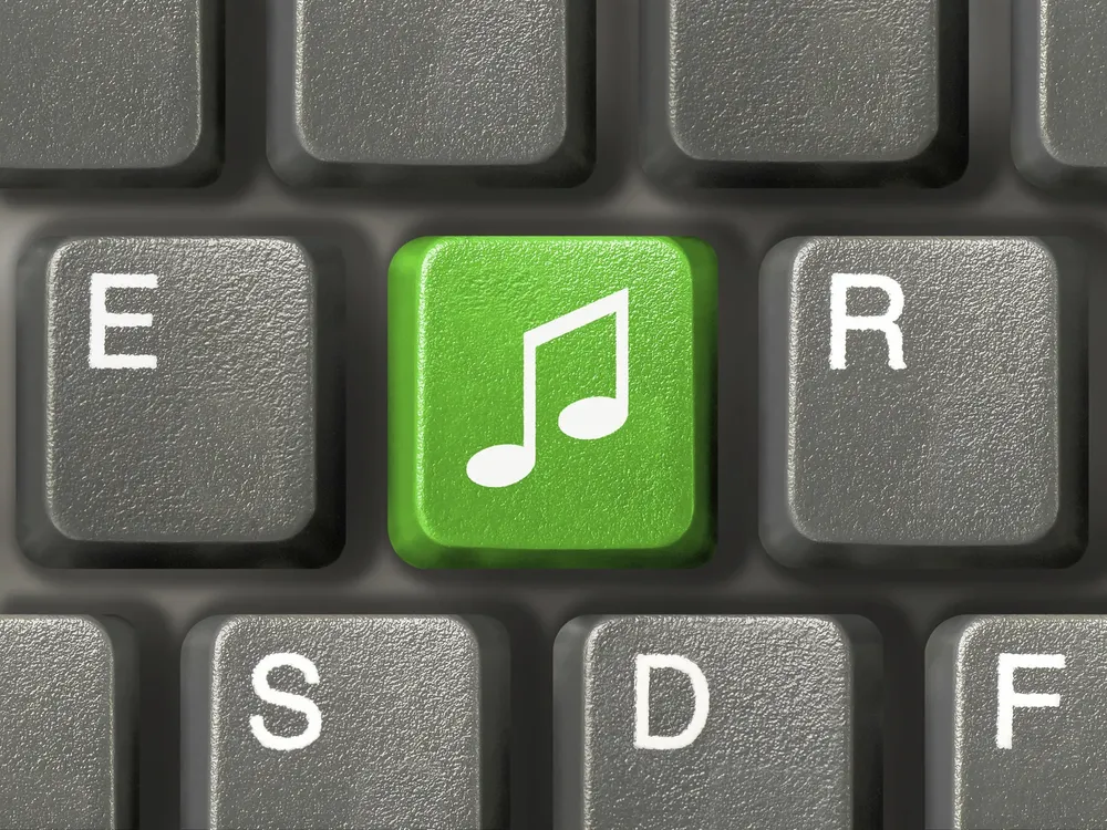 Computer keyboard (close-up) with green music key