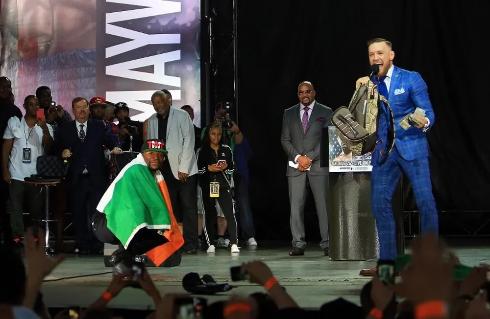 Mayweather con la bandera de Irlanda y McGregor con el dinero del estadounidense Mayweather con la bandera de Irlanda y McGregor con el dinero del estadounidense