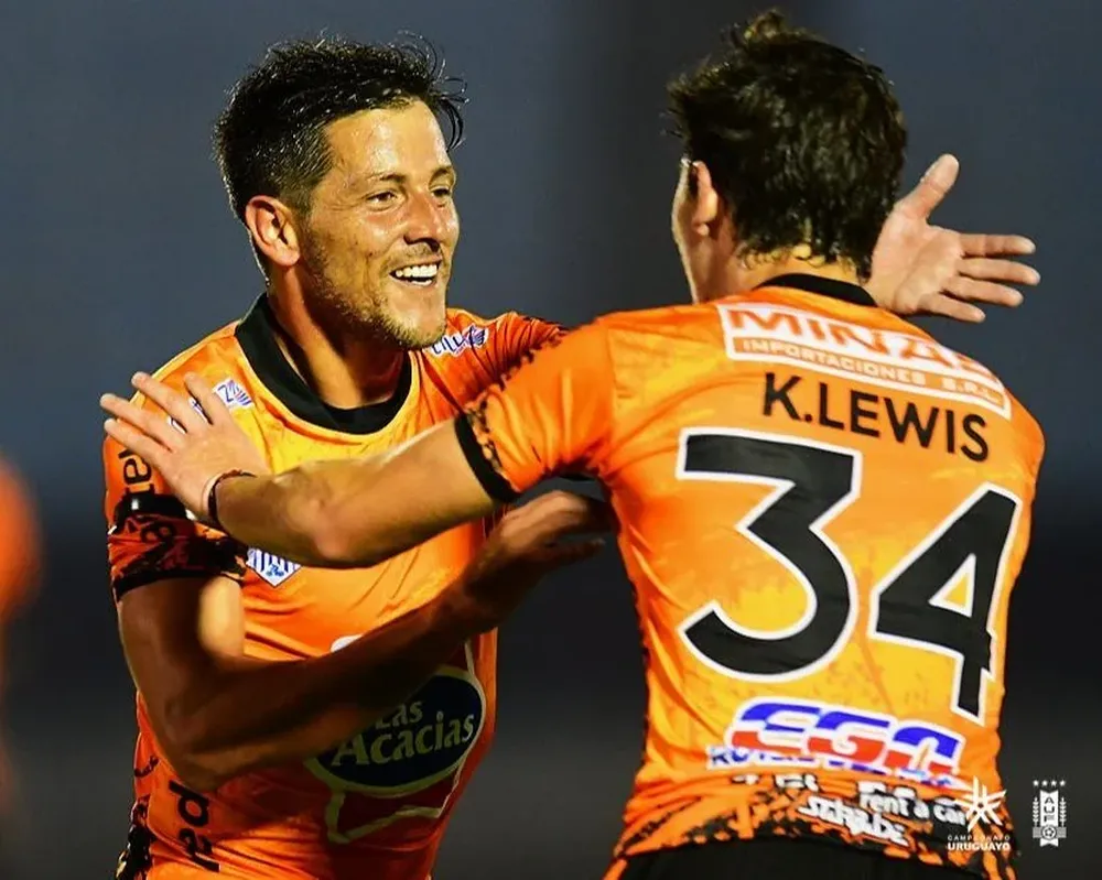 Pablo Olivera festeja su gol con Kevin Lewis