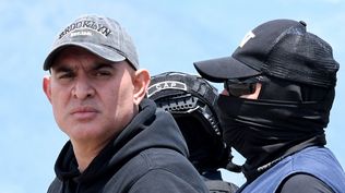 El presunto narcotraficante hondureño Mario José Calix, alias El Cubeta, es escoltado por miembros de la Dirección Nacional de Fuerzas Especiales (Cobras) durante su extradición a Estados Unidos en la base de Palmerola en Comayagua, a 50 km al norte de Tegucigalpa, el 4 de septiembre de 2024.