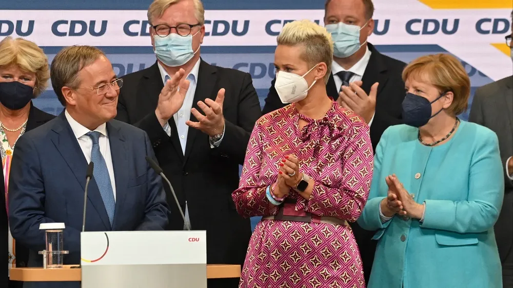 El líder de la Unión Demócrata Cristiana (CDU) y candidato a canciller Armin Laschet (izq.) Reacciona en el escenario mientras se dirige a la audiencia en la sede de la CDU después de que las estimaciones fueran transmitidas por televisión en Berlín