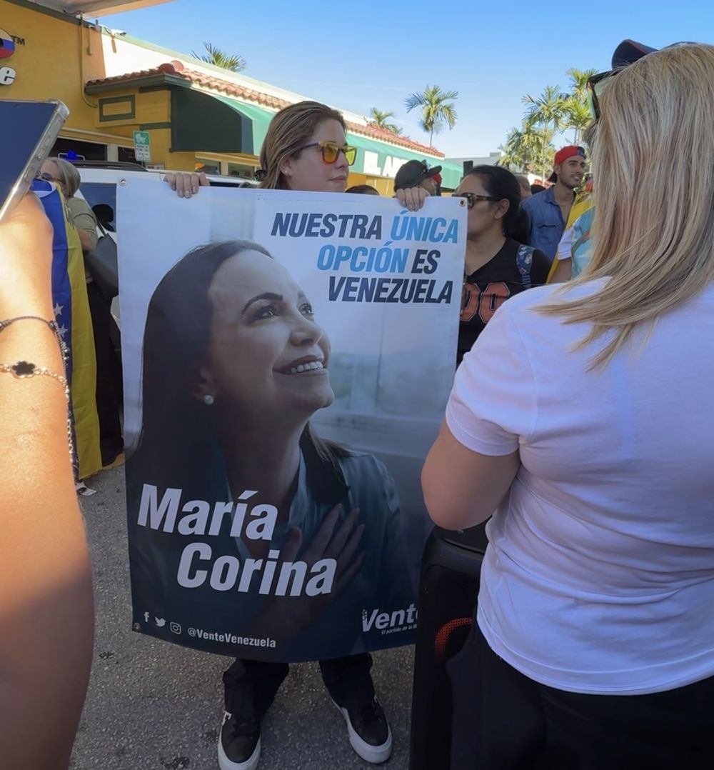Mujeres reunidas en torno a un parlante en el que sonó el mensaje de Machado.