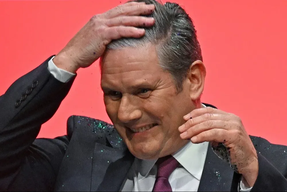 Keir Starmer se limpia la brillantina que un opositor interno de su partido le arrojó cuando subía al escenario del congreso laborista