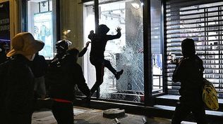 Varias personas rompen un escaparate el domingo en París.
