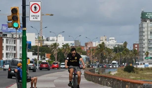 Pronóstico del clima en Uruguay según Inumet para el miércoles 18 de septiembreCiclista en la Rambla de Montevideo, al lado de un cartel de circule a pie