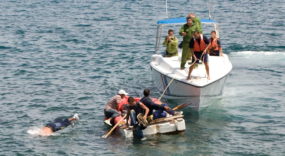 En esta imagen de archivo, guardacostas cubanos ordenan a los aspirantes a emigrados cubanos en un bote casero que regresen a la costa luego de que su intento de escapar de la isla fuera frustrado por las corrientes marinas