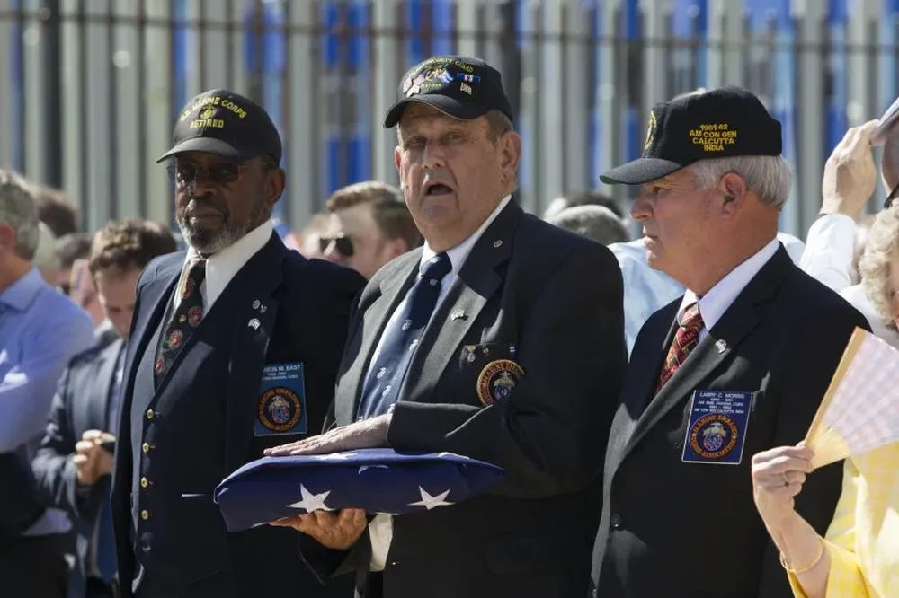 Los tres marines que bajaron la bandera en 1961 se la entregaron a los que la izarían el viernes pasado.
