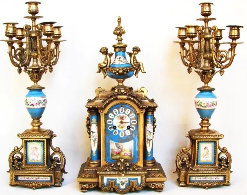 garniture francesa de bronce y porcelana francesa de Sevres compuesta de: reloj y par de candelabros de cinco luces.