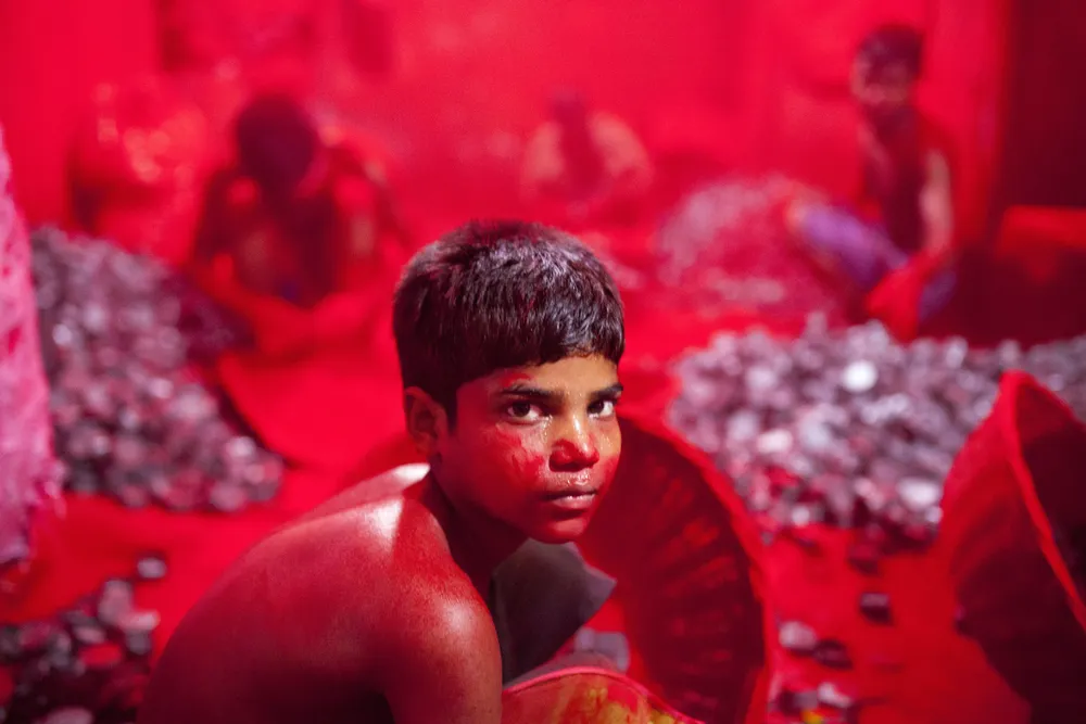 Este niño trabaja bajo condiciones riesgosas en una fábrica de pigmento rojo hecho a base de cinabrio, en Bangladesh. Ahí, ese color es símbolo de buena fortuna.