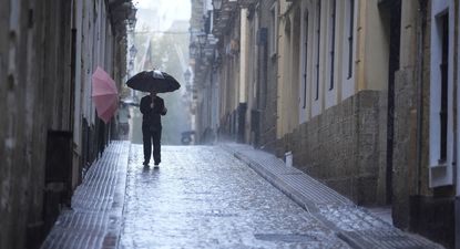 Un hombre bajo su paragüas durante una intensa lluvia en Cádiz, Andalucía. EUROPA PRESS
