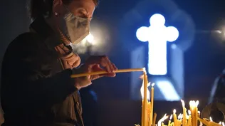 Una mujer cristiana enciende velas durante la Pascua