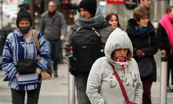 Personas muy abrigadas circulan por las calles de Madrid