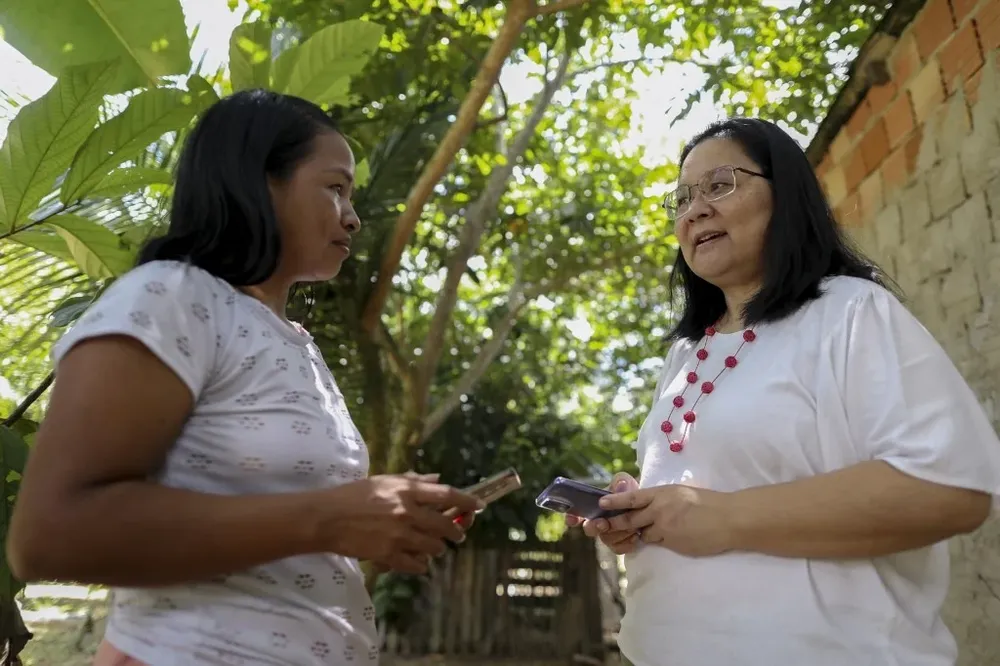 La creadora del proyecto, Noemia Ishikawa (izq.), y la mujer indígena Tikuna, Cristina Mariano (der.), hablan sobre cómo usar la aplicación en Manaos, estado de Amazonas.