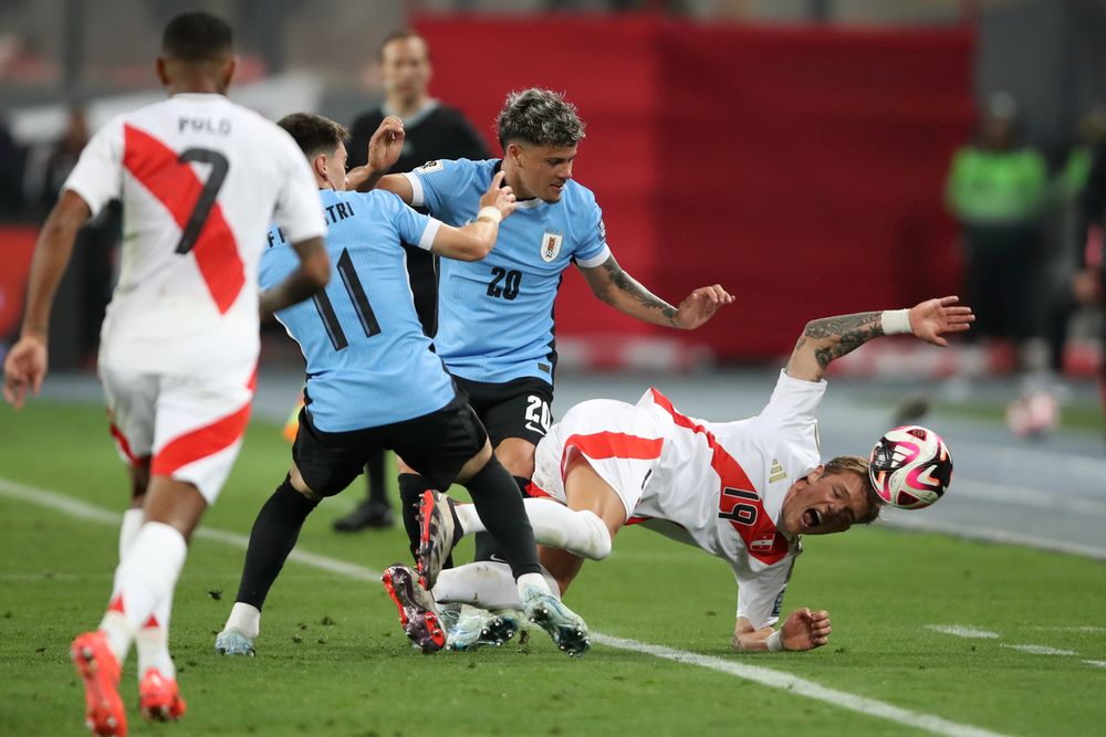 Oliver Sonne de Perú ante Maximiliano Araújo de la selección de Uruguay