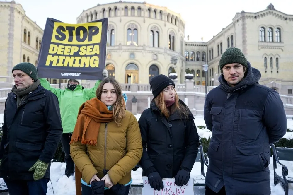 El legislador noruego Aril Hermstad (izq.) acompaña a un grupo de activistas climáticos en la protesta frente al Parlamento.