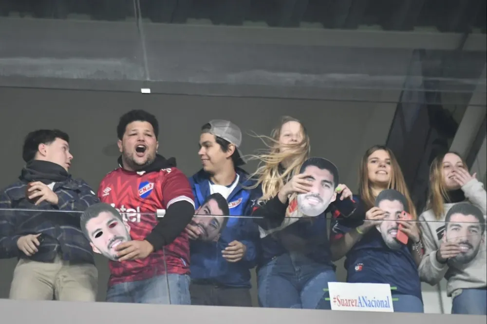 Hinchas de Nacional con las caretas de Suárez