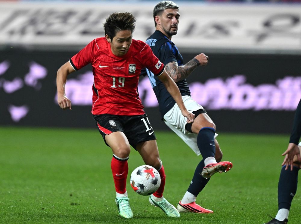 Lee Kang-in de Corea del Sur pelea por el balón con Giorgian De Arrascaeta de la selección uruguaya