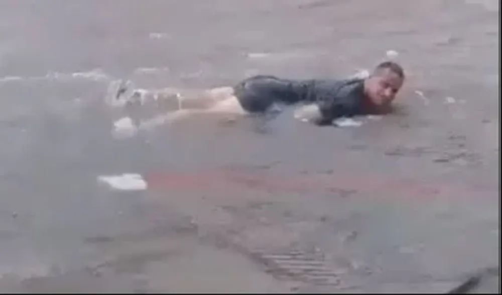 Momento en el que el vecino se tira a la calle a nadar