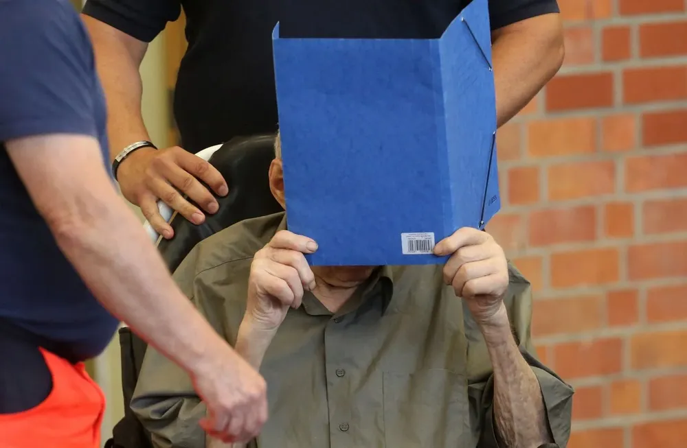 Josef Schuetz de 101 años se tapa la cara mientras llega a declarar este martes 28 de junio