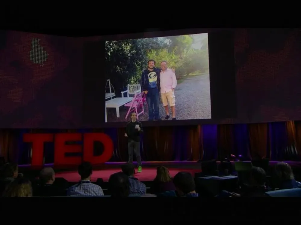 Gebbia en la charla TED con la foto de Artigas y Casciari de fondo