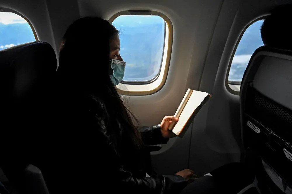 Pasajera vistiendo una mascarilla durante un viaje de avión