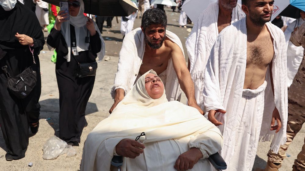 Una mujer afectada por el calor abrasador es empujada en una silla de ruedas en las afueras de La Meca.