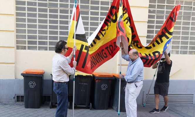 Varios hombres sujetan una pancarta contra el presidente del Gobierno en el colegio de Nuestra Señora del Buen Consejo, donde votaron Pedro Sánchez y Begoña Gómez