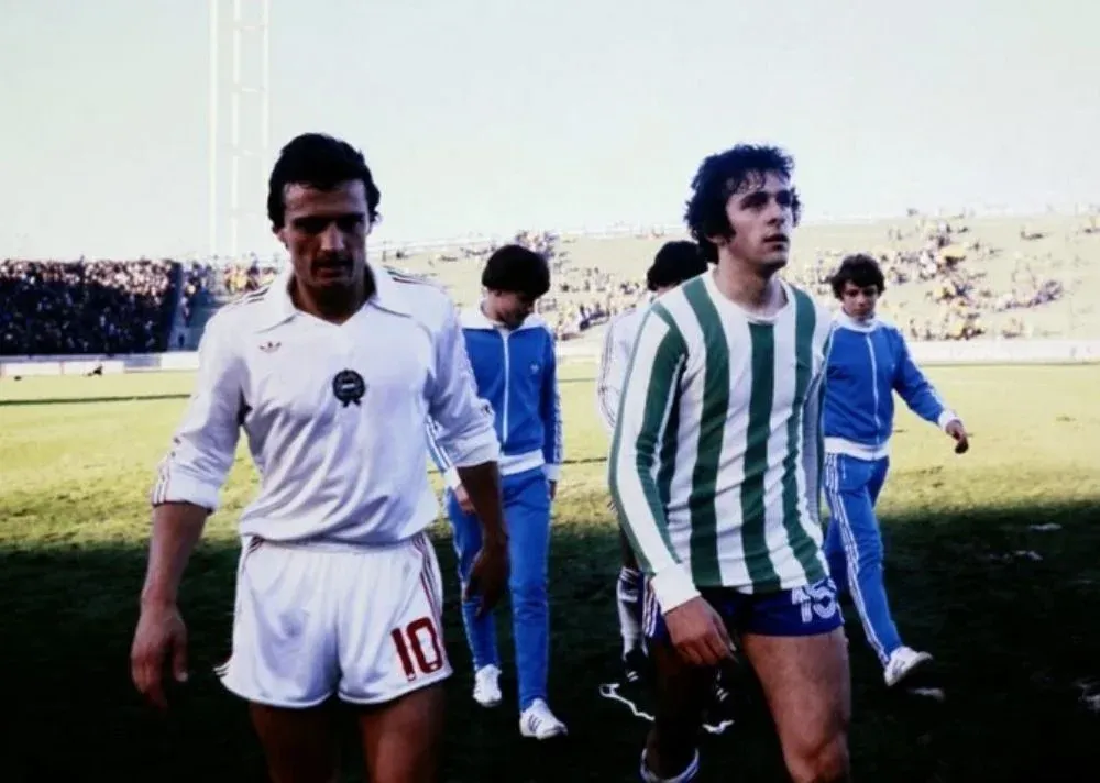 El francés Michel Platini de Francia con la camiseta de Kimberley de Mar del Plata, sale de la cancha con el húngaro Sandor Pinter