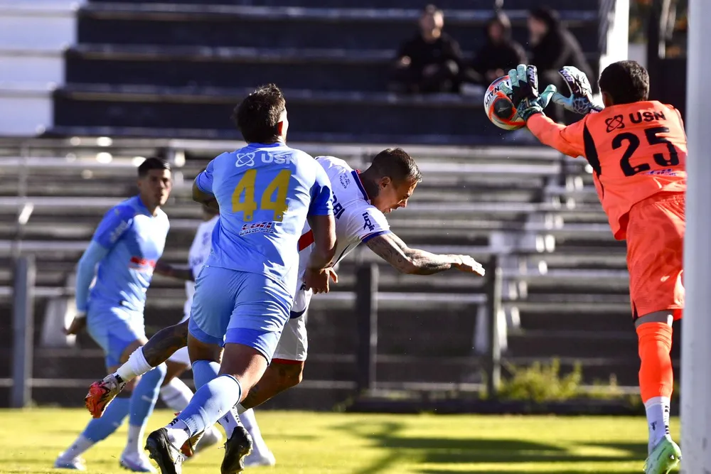 Francisco Tinaglini de Montevideo City Torque se queda con la pelota ante la llegada de Eduardo Vargas de Nacional por el Torneo Intermedio